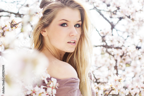 Photo: beautiful blonde girl in spring cherry garden beautiful blonde girl in spring cherry garden