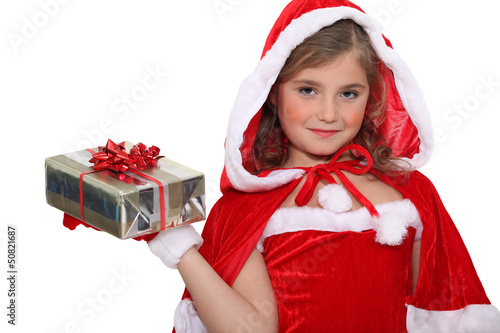 Photo: Little girl in a Santa costume with a wrapped gift Little girl in a Santa costume with a wrapped gift