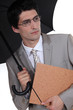 young businessman holding umbrella