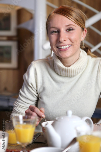 Photo: Smiling woman at the breakfast table Smiling woman at the breakfast table