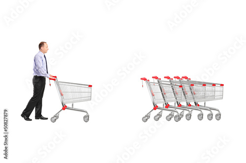 Photo: Full length portrait of a man returning an empty shopping cart Full length portrait of a man returning an empty shopping cart