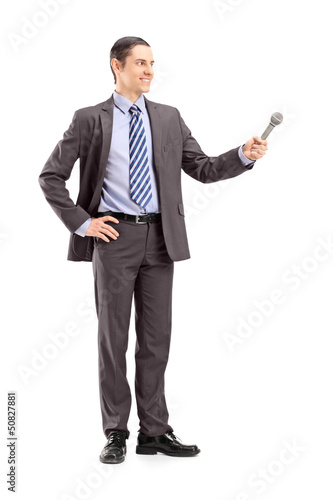 Photo: Full length portrait of a professional male reporter holding a m Full length portrait of a professional male reporter holding a m