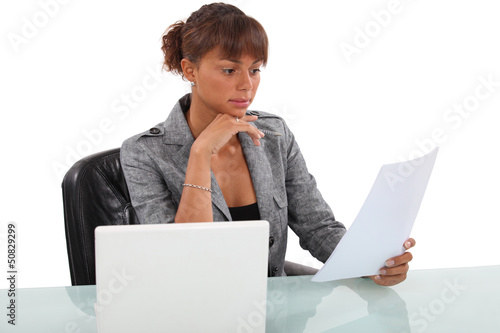 Photo: Woman carefully reading through document Woman carefully reading through document