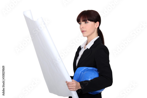 Photo: Female architect examining plans Female architect examining plans