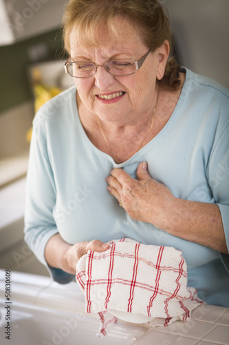Photo: Senior Adult Woman At Sink With Chest Pains Senior Adult Woman At Sink With Chest Pains