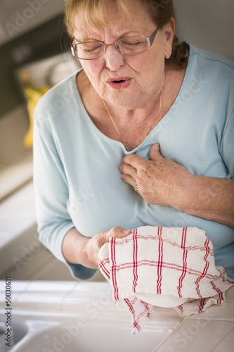 Photo: Senior Adult Woman At Sink With Chest Pains Senior Adult Woman At Sink With Chest Pains