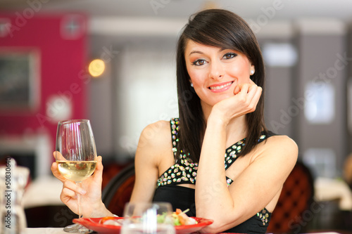 Photo: Woman toasting wine in a restaurant Woman toasting wine in a restaurant