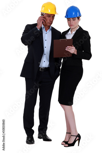Photo: Businesspeople holding a clipboard Businesspeople holding a clipboard