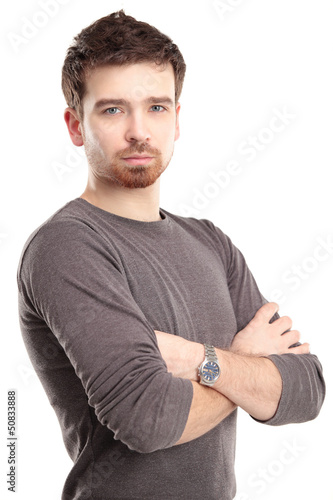 Photo: Casual young man looking at camera with arms crossed Casual young man looking at camera with arms crossed