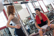 Photo: Young friends talking at the gym while training. Young friends talking at the gym while training.