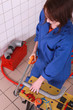 Female plumber sawing pipe