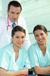 Doctor standing with two nurses at a nursing station