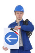 Electrician with a one way sign