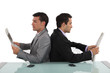 Two businessmen reading newspapers