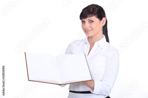 Photo: a waitress presenting a visitors book a waitress presenting a visitors book