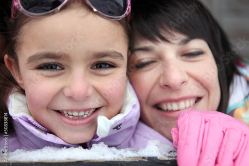 Photo: Mother and daughter giggling in the snow Mother and daughter giggling in the snow