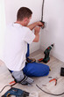 electrician screwing an electrical outlet