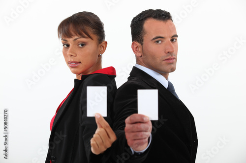 Photo: Businessman and woman holding calling cards Businessman and woman holding calling cards