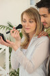 Woman applying blusher whilst boyfriend watches