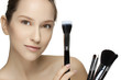 Portrait of the beautiful woman with make-up brushes.
