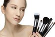 Portrait of the beautiful woman with make-up brushes.