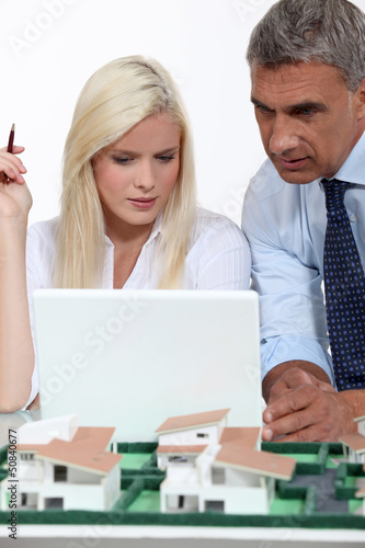 Photo: real estate businessman and his secretary working real estate businessman and his secretary working