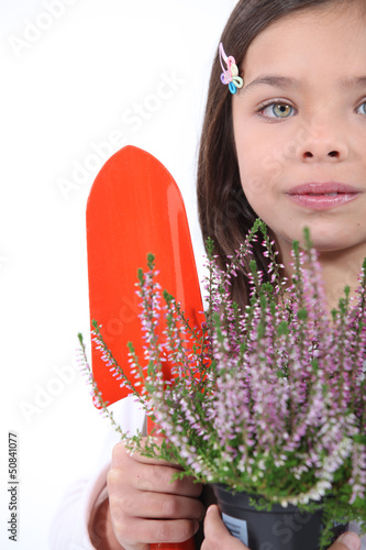 Photo: little girl with shy smile gardening little girl with shy smile gardening