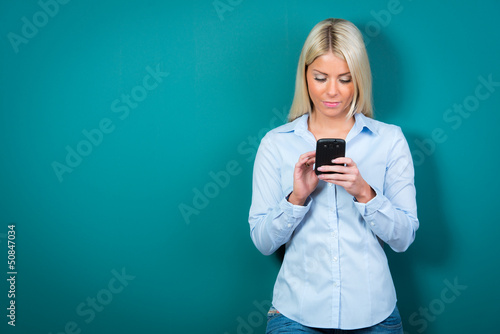 Photo: junge frau liest eine nachricht auf dem handy junge frau liest eine nachricht auf dem handy