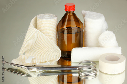 Photo: First aid kit for bandaging on grey background First aid kit for bandaging on grey background