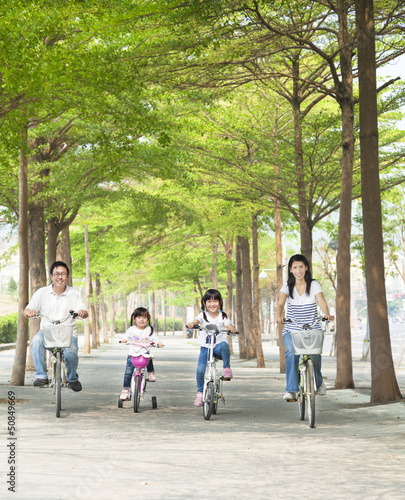 Photo: happy family riding bicycle in the park happy family riding bicycle in the park
