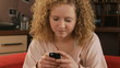 Young girl sitting on a couch and texting