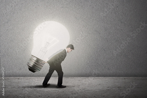 Photo: Businessman carry bright light bulb Businessman carry bright light bulb