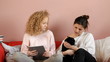 Two teenagers sitting on sofa cary on a cat - tracking shot