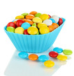 Colorful candies in cupcake case isolated on white