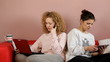 Two girls leisure on couch in living room - tracking shot