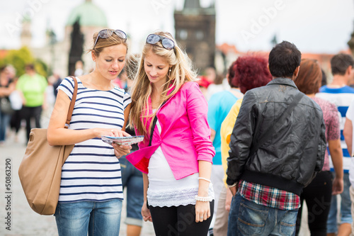 Photo: Two female tourists walking along the Charles Bridge Two female tourists walking along the Charles Bridge