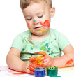 Little boy is playing with paints