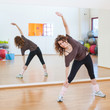 Photo: Young woman stretching her leg in the gym. Young woman stretching her leg in the gym.