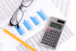 Documents, calculator and glasses close-up.