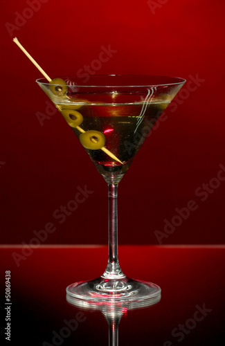 Photo: Martini glass and olives on dark background Martini glass and olives on dark background