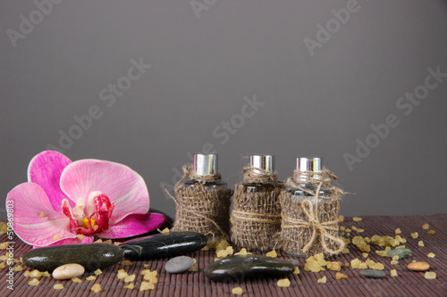 Photo: Spa oil on bamboo mat on bright background Spa oil on bamboo mat on bright background