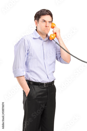 Photo: Angry man having a telephone conversation Angry man having a telephone conversation