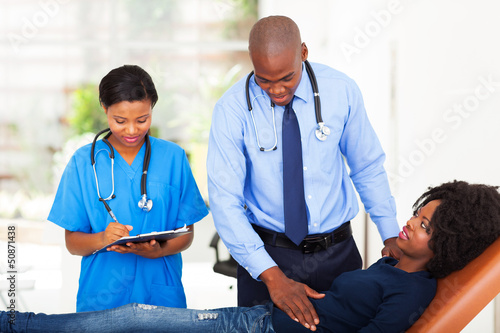 Photo: african doctor examining female patient african doctor examining female patient