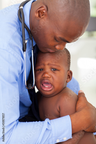 Photo: caring african male pediatric doctor comforting baby boy caring african male pediatric doctor comforting baby boy