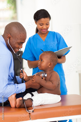 Photo: cute african little patient pulling doctor stethoscope cute african little patient pulling doctor stethoscope