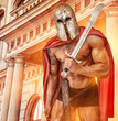 Powerfull warrior in red mantle and helmet near the building wit