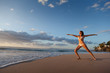 Photo: Woman in Warrior yoga pose on tropical beach Woman in Warrior yoga pose on tropical beach