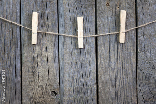 Photo: Clothespins on rope and empty vintage wooden planks background Clothespins on rope and empty vintage wooden planks background