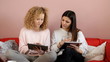 Teen friends relex with tablets on a couch