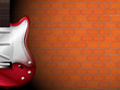 A guitar in front of a brick wall